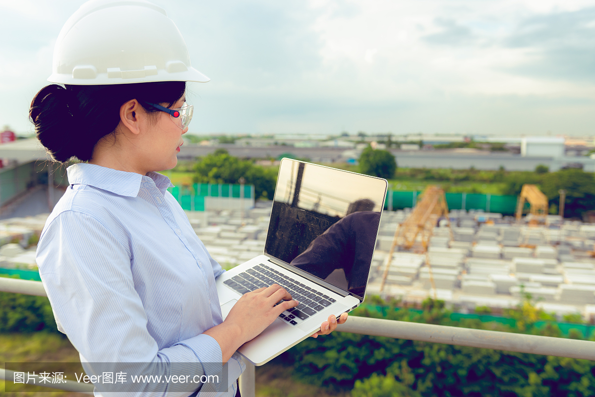 女工程師正在用筆記本電腦檢查工廠里的預(yù)制混凝土產(chǎn)品